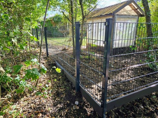 Zaun hinter dem Tomaten-Gewächshaus